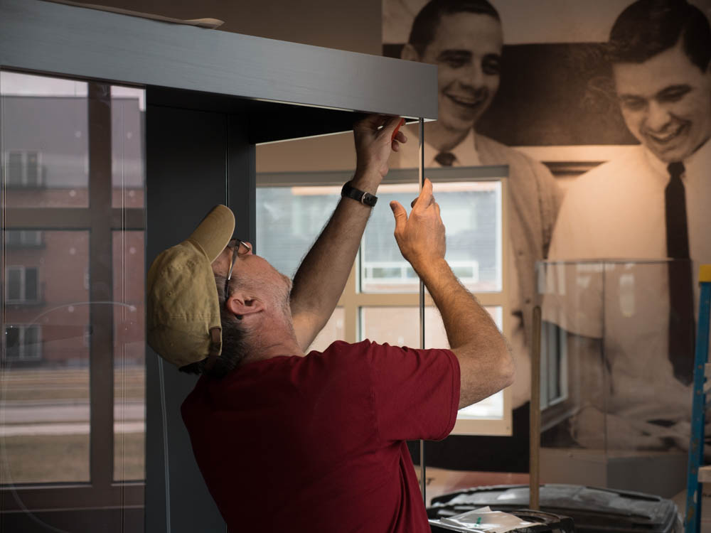 Mark Andres assembling a display case in the Pizza Hut Museum in Wichita, Kansas.