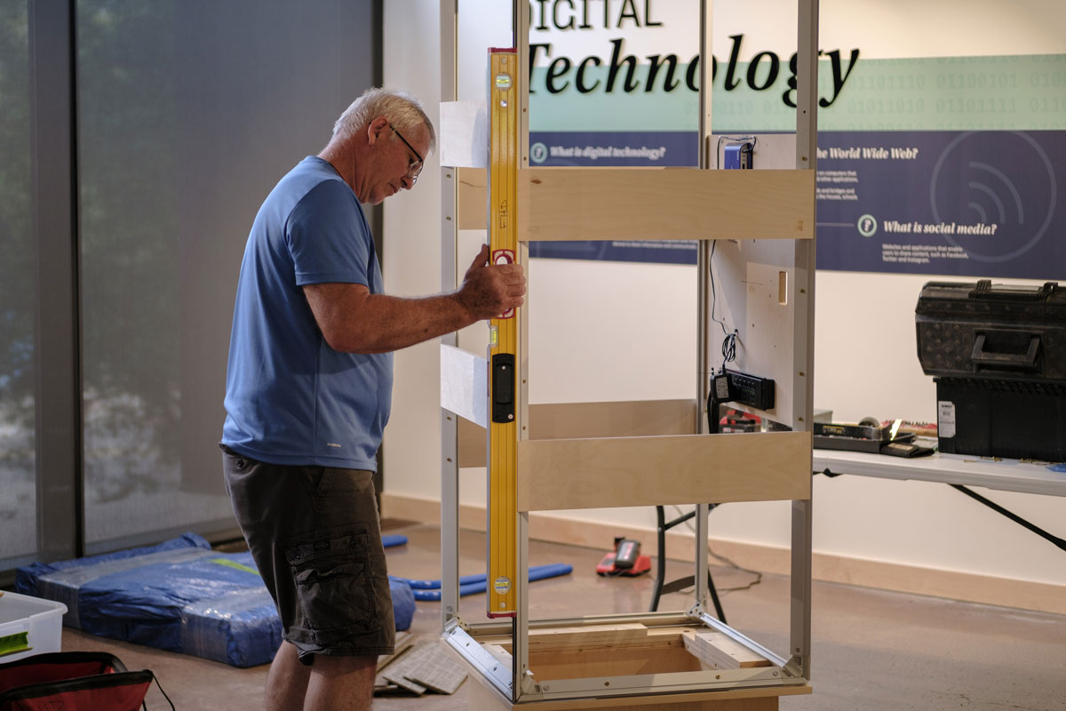Graham Unruh interacting with the digital touchscreens on the exhibit columns.