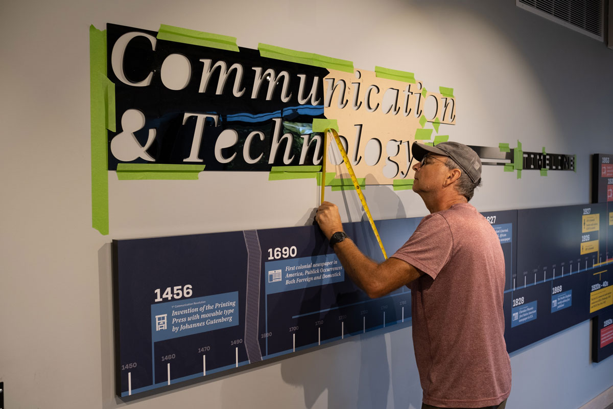Graham Unruh interacting with the digital touchscreens on the exhibit columns.